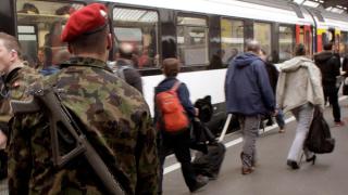 A Swiss soldier carries his assault rifle as he disembarks from a train at the central railway station in Zurich, Switzerland April 5, 2013. To match story SWISS-EU/GUNS REUTERS/Arnd Wiegmann/File Photos